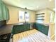 Bright kitchen with unique green cabinets, dark countertops, stainless steel appliances, and wood grain flooring at 7537 Brisa Del Mar Ave, Las Vegas, NV 89179