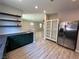 Open kitchen area with stainless steel refrigerator and green cabinetry at 7537 Brisa Del Mar Ave, Las Vegas, NV 89179