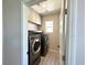 Convenient laundry room with modern appliances, overhead storage, and natural light at 7537 Brisa Del Mar Ave, Las Vegas, NV 89179