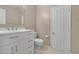 Modern bathroom featuring white vanity with gold hardware, tile floors and crisp white trim at 7720 Leavorite Dr, Las Vegas, NV 89128