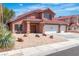 Charming two-story home featuring a three-car garage and a low-maintenance front yard with rock landscaping at 7720 Leavorite Dr, Las Vegas, NV 89128