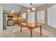 Well-lit kitchen with stainless steel appliances, granite countertops, wood cabinets, tile floors and table seating at 7720 Leavorite Dr, Las Vegas, NV 89128