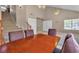 Spacious living room featuring neutral walls and tile flooring, stairs to the second floor, and a dining table at 7720 Leavorite Dr, Las Vegas, NV 89128