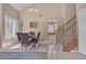 Spacious living room with stairs, neutral walls and tile flooring, a chandelier, and a dining table at 7720 Leavorite Dr, Las Vegas, NV 89128