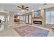 Open concept living room and kitchen with fireplace, ceiling fan and tile floors at 7720 Leavorite Dr, Las Vegas, NV 89128