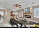 Virtually staged living room with tile flooring, fireplace, and views into the kitchen at 7720 Leavorite Dr, Las Vegas, NV 89128