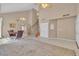 Spacious living room featuring neutral walls and tile flooring, stairs to the second floor, and chandelier lighting at 7720 Leavorite Dr, Las Vegas, NV 89128