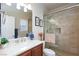 Well-lit bathroom with a glass-enclosed shower and wooden vanity at 7816 Glowing Peak St, Las Vegas, NV 89131