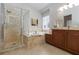 This bathroom features a glass shower enclosure, soaking tub, and granite countertops at 7816 Glowing Peak St, Las Vegas, NV 89131