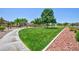 Spacious front lawn with mature shade trees and colorful landscaping in a well-maintained community at 7816 Glowing Peak St, Las Vegas, NV 89131