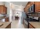 Modern kitchen featuring stainless steel appliances, abundant wood cabinetry, and a view to the dining area at 7816 Glowing Peak St, Las Vegas, NV 89131