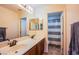 Bathroom featuring double sinks, a large mirror, and a separate shower area with a striped curtain at 9022 Sosa Creek Ave, Las Vegas, NV 89149