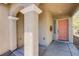 View of the front porch and entryway with columns and a peach-colored front door at 9022 Sosa Creek Ave, Las Vegas, NV 89149