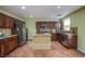 Well-equipped kitchen featuring stainless steel appliances, dark wood cabinetry, and a stylish kitchen island at 9022 Sosa Creek Ave, Las Vegas, NV 89149