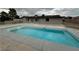 Backyard view of the pool and patio area with concrete decking and the exterior of the home at 9340 W Washburn Rd, Las Vegas, NV 89149