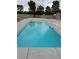 View of the sparkling in-ground pool with updated stone coping and lush landscaping at 9340 W Washburn Rd, Las Vegas, NV 89149