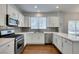 Bright kitchen with white cabinets, stainless steel appliances, and a modern backsplash at 1013 Corsica Ln, Las Vegas, NV 89144
