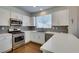 Bright kitchen with stainless steel appliances, white cabinets, tiled backsplash, and ample counter space for cooking at 1013 Corsica Ln, Las Vegas, NV 89144