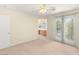 Bright bedroom with ceiling fan, neutral carpet and walls, and balcony access at 10437 Coyote Cub Ave, Las Vegas, NV 89129