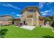 A backyard features artificial grass, a patio, a pergola and a two-story house at 10645 Lace Vine Arbor Ave, Las Vegas, NV 89144