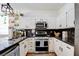 Modern kitchen featuring granite countertops, white cabinets, and stainless steel appliances at 10645 Lace Vine Arbor Ave, Las Vegas, NV 89144