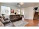 Open-concept living room featuring hardwood floors, neutral walls, comfortable seating, and easy access to the staircase at 10645 Lace Vine Arbor Ave, Las Vegas, NV 89144