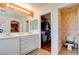 Large bathroom features double sink vanity, well lit mirror and access to walk-in closet and toilet at 10645 Lace Vine Arbor Ave, Las Vegas, NV 89144