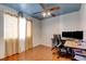 Home office featuring a ceiling fan, natural light and a large desk area with wood floors at 10645 Lace Vine Arbor Ave, Las Vegas, NV 89144