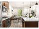Open kitchen boasts stainless steel appliances, stylish lighting, and eat-in dining space at 11756 Emerald Lake Ave, Las Vegas, NV 89138