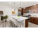 Modern kitchen island with seating, stainless appliances, and sleek dark wood cabinetry at 11756 Emerald Lake Ave, Las Vegas, NV 89138