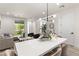 Bright, open concept living and dining area with modern light fixture and stylish decor at 11756 Emerald Lake Ave, Las Vegas, NV 89138