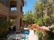 Fully landscaped backyard featuring trees and shrubs, patio furniture, and desert landscaping at 11832 Arenoso Dr, Las Vegas, NV 89138