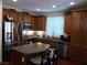 Well-lit kitchen features stainless steel appliances and spacious dark wood cabinets for storage at 11832 Arenoso Dr, Las Vegas, NV 89138