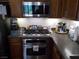 Modern kitchen featuring stainless steel microwave and oven, gas cooktop, and solid surface countertops at 11832 Arenoso Dr, Las Vegas, NV 89138