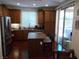 Well-lit kitchen features a stainless steel refrigerator, island with breakfast bar, and sliding glass door to the backyard at 11832 Arenoso Dr, Las Vegas, NV 89138