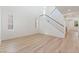 Sunlit living room showcases sleek wood-look floors, a staircase with white railing and tall ceilings with bright natural light at 11900 Calle De Sol Dr, Las Vegas, NV 89138