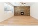Living room boasts a stone accent wall with a fireplace, wood-look floors, and abundant natural light from a large window at 11900 Calle De Sol Dr, Las Vegas, NV 89138