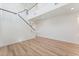Open-concept living space features wood-look floors, a staircase, and freshly painted white walls, offering a blank canvas at 11900 Calle De Sol Dr, Las Vegas, NV 89138