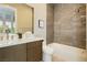 Bathroom featuring a shower over tub, elegant vanity and sink with wood cabinets at 12382 Tudor Arch Dr, Las Vegas, NV 89138