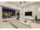 Open-concept living room with modern furnishings and seamless indoor/outdoor flow to a pool area at 12382 Tudor Arch Dr, Las Vegas, NV 89138