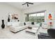 Bright living room with white sectional, modern decor, and sliding glass doors to a pool at 12382 Tudor Arch Dr, Las Vegas, NV 89138