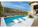 Inviting pool area with built-in sun loungers, lush landscaping, and an outdoor seating area at 12382 Tudor Arch Dr, Las Vegas, NV 89138