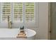 Close up of a tub with white shutters and a glass shower at 17 Winding Rd, Henderson, NV 89052