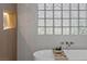 Close-up of a soaking tub with glass block window providing natural light in this luxurious bathroom at 17 Winding Rd, Henderson, NV 89052