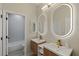 Modern bathroom featuring a double sink vanity with illuminated mirrors and wood drawers at 17 Winding Rd, Henderson, NV 89052