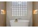 Freestanding tub in a modern bathroom with tiled walls and a glass block window for natural light at 17 Winding Rd, Henderson, NV 89052