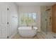 Bathroom featuring large tub next to shuttered window and a glass shower at 17 Winding Rd, Henderson, NV 89052