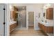 Modern bathroom showing a walk-in shower and separate vanities with wood cabinets at 17 Winding Rd, Henderson, NV 89052