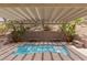 Inviting backyard pool area featuring bench seating and a lattice-covered patio for shade and relaxation at 17 Winding Rd, Henderson, NV 89052