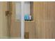 Close up of walk in shower with bronze fixtures, textured walls, and inset tiled toiletries display at 17 Winding Rd, Henderson, NV 89052
